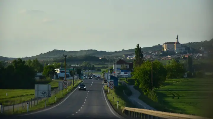 Car on an open European road with mountains ahead