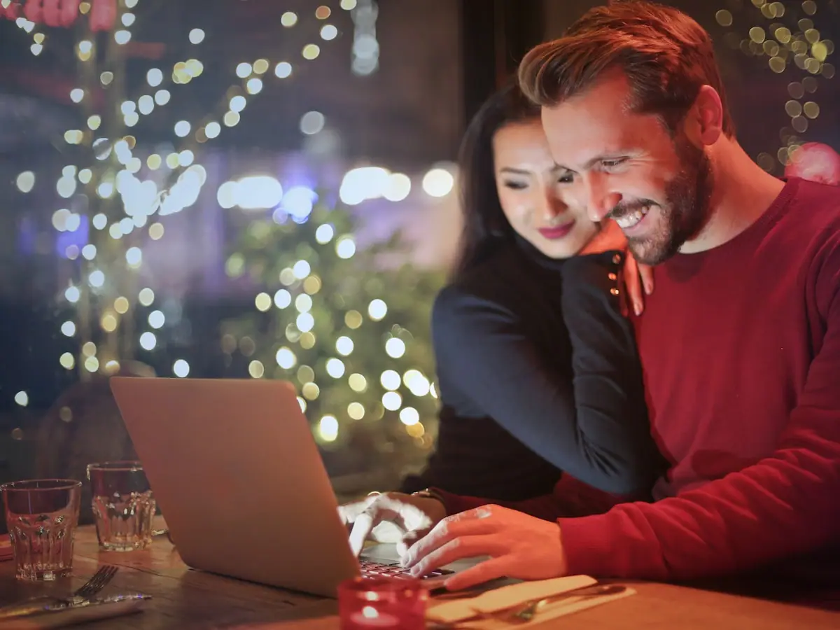 Couple planning a trip together over a laptop and map