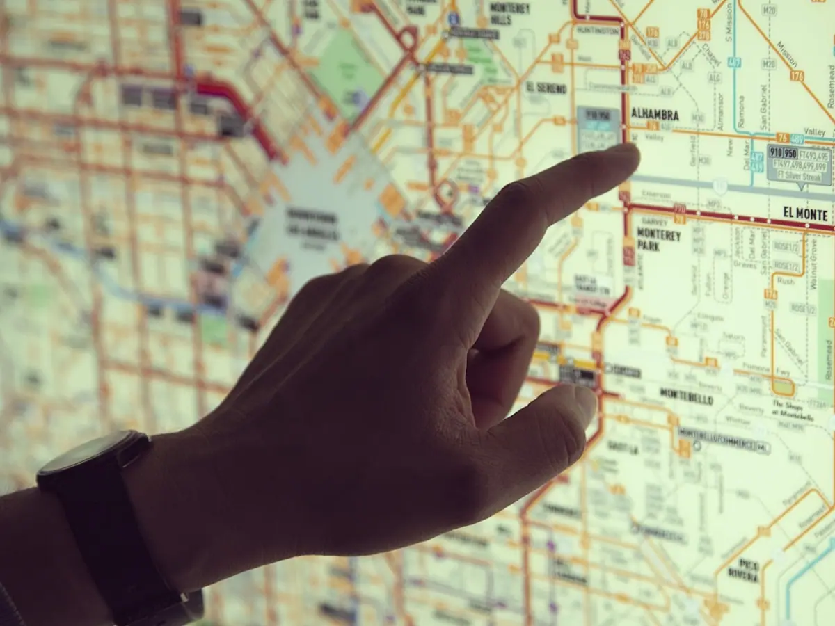 Hands marking a driving route on a paper map